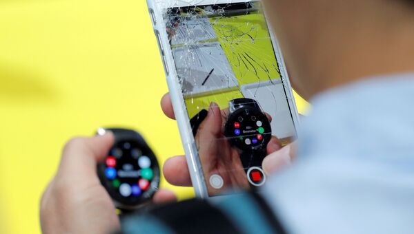 Посетитель фотографирует на iPhone часы Samsung Galaxy Watch на презентации Galaxy Unpacked в Нью-Йорке