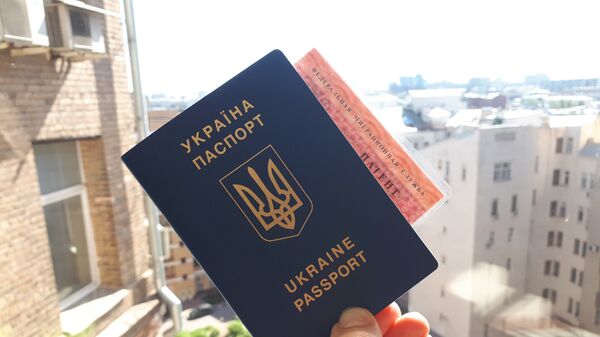 Гражданин Украины держит паспорт и патент на работу в РФ Гражданин Украины держит паспорт и патент на работу в РФ