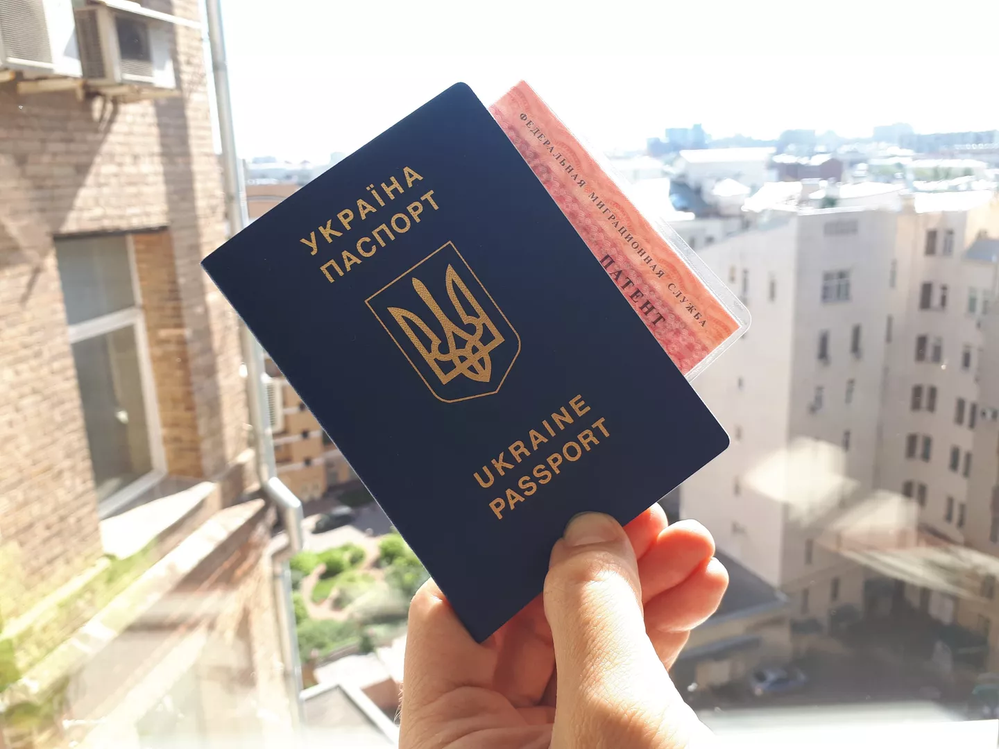 Гражданин Украины держит паспорт и патент на работу в РФ 