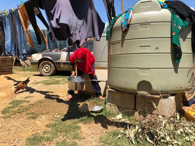 Женщина набирает воду в палаточном лагере для сирийских беженцев в центральном Бекаа в поселении Каб Эльяс. 11 августа 2018 Женщина набирает воду в палаточном лагере для сирийских беженцев в центральном Бекаа в поселении Каб Эльяс. 11 августа 2018