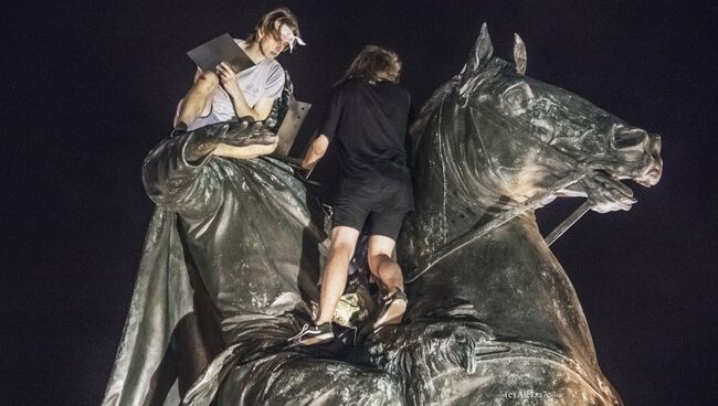 Молодые люди во время установки мангала на скульптуру Медного всадника в Санкт-Петербурге. 5 августа 2018