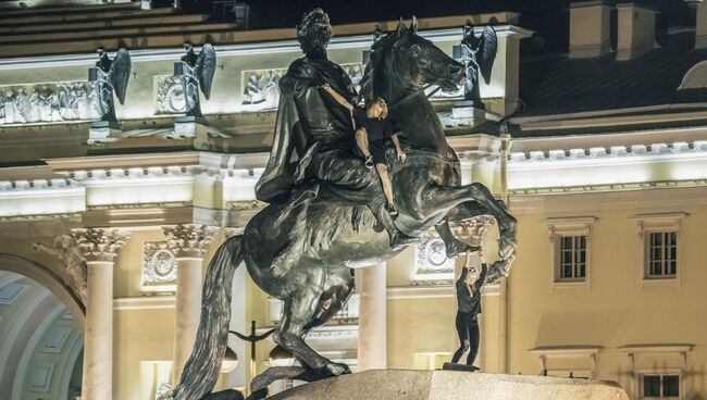 Молодые люди на скульптуре Медного всадника в Санкт-Петербурге. 5 августа 2018