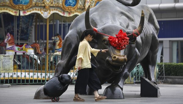 Девушка проходит мимо статуи быка в Пекине