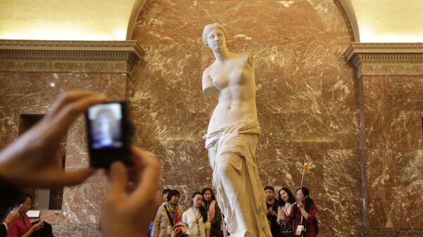 Китайские туристы у скульптуры Венера Милосская в Лувре