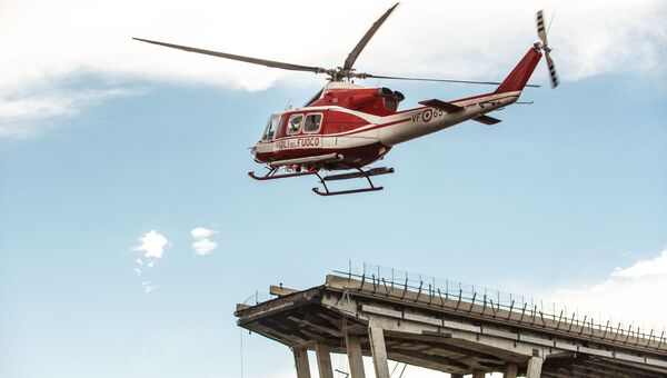 Пожарный вертолет над местом обрушения автомобильного моста Моранди в Генуе
