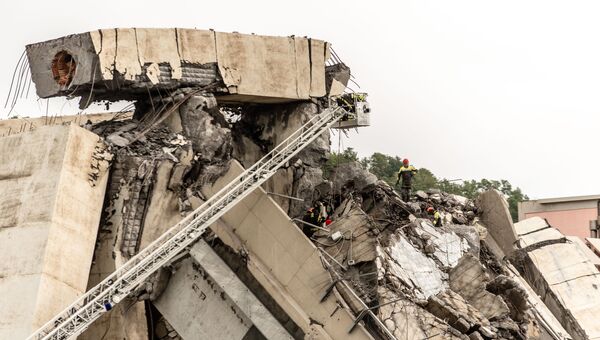 Сотрудники спасательной службы работают на месте обрушения автомобильного моста Моранди в Генуе
