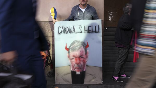 Протестующий с плакатом у здания суда в Мельбурне, где рассматривается дело в отношении кардинала Джорджа Пелла. 1 мая 2018