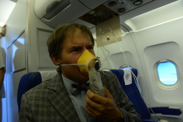 Пассажир в кислородной маске во время учений по отработке нештатных ситуаций на борту Пассажир в кислородной маске во время учений по отработке нештатных ситуаций на борту