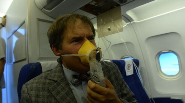 Пассажир в кислородной маске во время учений по отработке нештатных ситуаций на борту