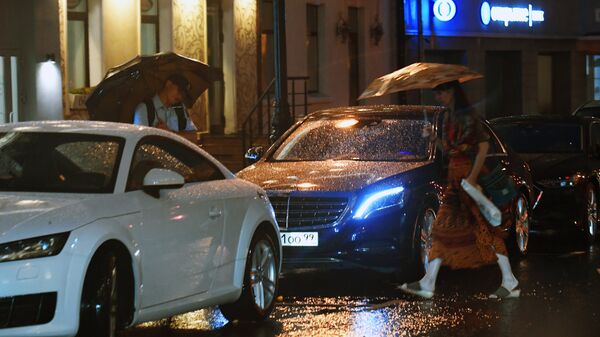 Прохожие на улице Москвы во время дождя