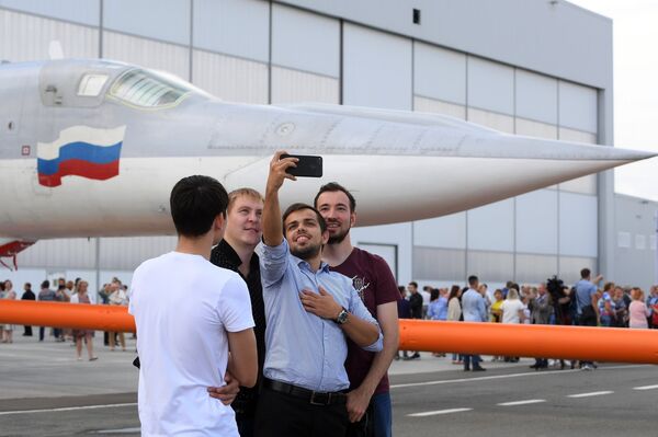 Сотрудники завода делают селфи на фоне самолета во время выкатки для наземных и летных испытаний модернизированного бомбардировщика Ту-22М3М на Казанском авиационном заводе имени С.П. Горбунова