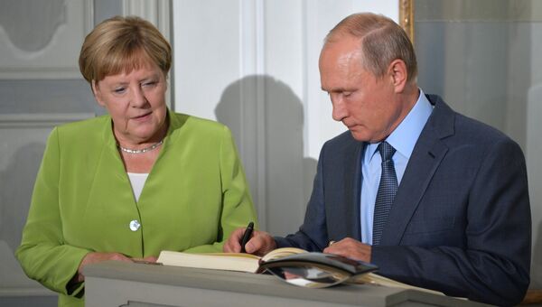 Президент РФ Владимир Путин оставляет запись в книге почетных гостей во время встречи с федеральным канцлером ФРГ Ангелой Меркель в резиденции правительства ФРГ Мезеберг. 18 августа 2018
