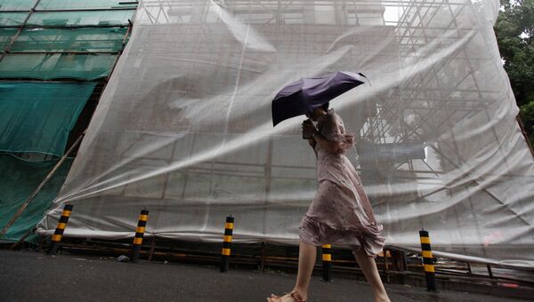 Женщина с зонтом сопротивляется ветру, принесенному тайфуном Румбия, в Янчжоу, провинция Цзянсу, Китай. 17 августа 2018