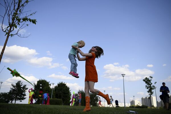 Женщина с ребенком в Братеевском каскадном парке Москвы, где проходит фестиваль фейерверков Ростех