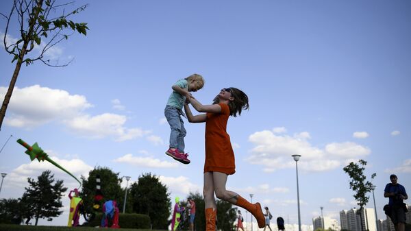 Женщина с ребенком в Братеевском каскадном парке Москвы, где проходит фестиваль фейерверков Ростех