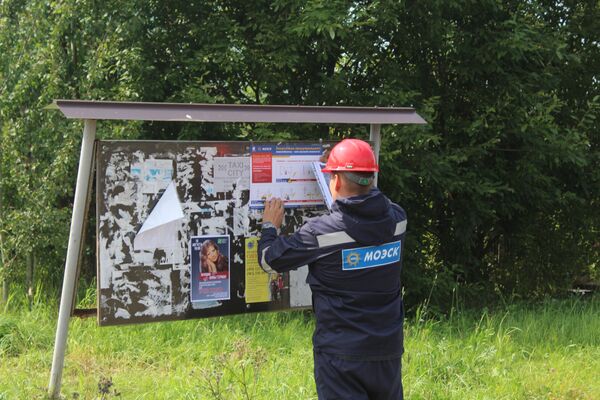 Сотрудник МОЭСК вешает памятку в д. Пучково Сотрудник МОЭСК вешает памятку в д. Пучково
