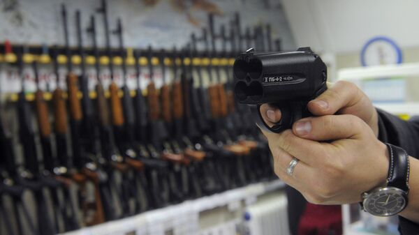 Покупатель осматривает травматический пистолет Оса в одном из оружейных магазинов Москвы