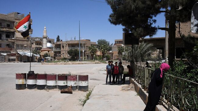 Жители на улице в сирийском городе Дейр-эз-Зор. Архивное фото