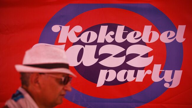 Прохожий у информационного баннера Международного джазового фестиваля Koktebel Jazz Party в Крыму