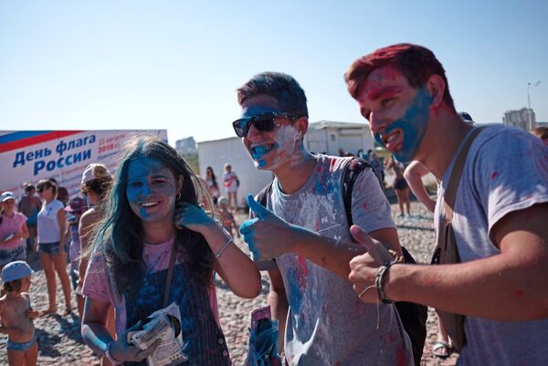Участники фестиваля триколора на пляжном курорте Суджукская коса во время празднования Дня государственного флага Российской Федерации в Новороссийске