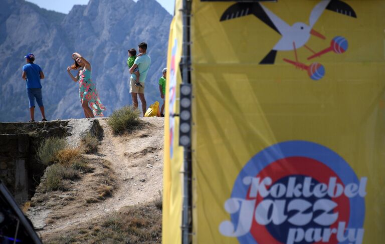 Отдыхающие у баннеров с логотипом музыкального фестиваля Koktebel Jazz Party 2018 Отдыхающие у баннеров с логотипом музыкального фестиваля Koktebel Jazz Party 2018