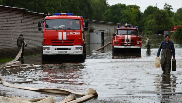 Сотрудники МЧС РФ ликвидируют последствия паводка на одной из улиц в Уссурийске. 27 августа 2018