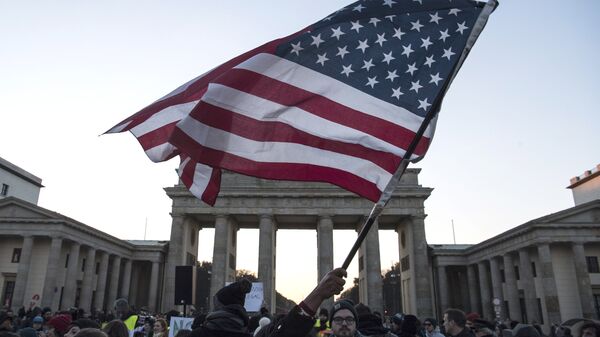 Флаг США во время акции протеста у Бранденбургских ворот в Берлине
