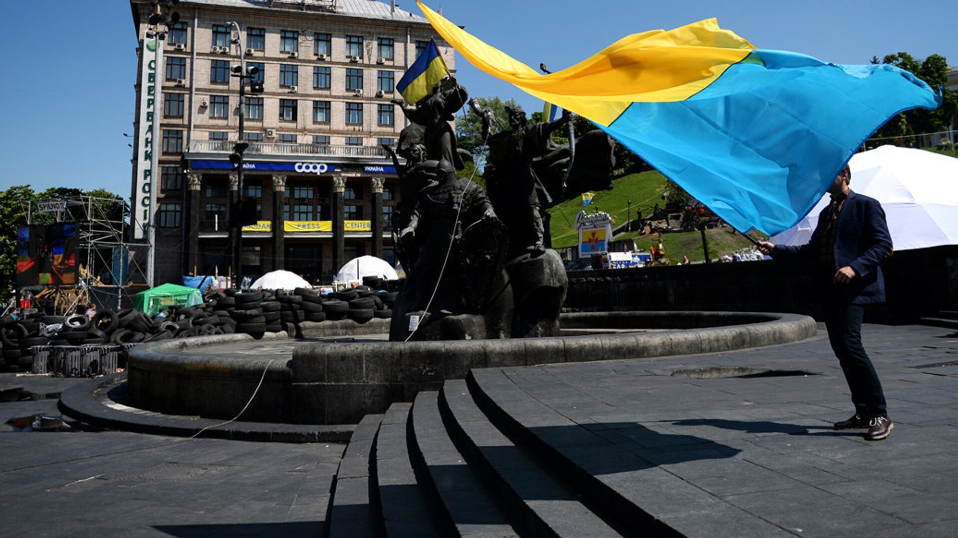 Мужчина с украинским флагом у памятника основателям Киева на площади Независимости - РИА Новости, 1920, 18.09.2022