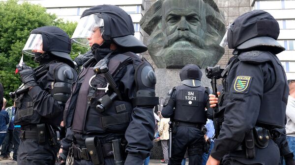 Полицейские рядом со скульптурой Карла Маркса во время беспорядков в Хемнице. Архивное фото