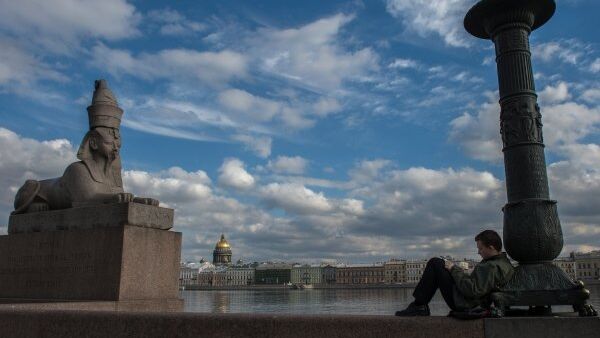 Молодой человек рисует на Университетской набережной в Санкт-Петербурге