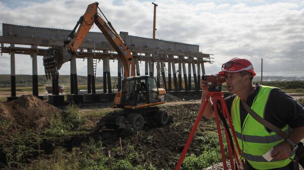 Рабочий на строительстве участка федеральной трассы Р-217 Кавказ в объезд озера Тамбукан протяженностью 15 километров в Кабардино-Балкарии