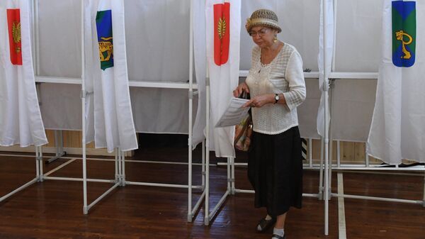 Избирательница в единый день голосования на избирательном участке во Владивостоке.