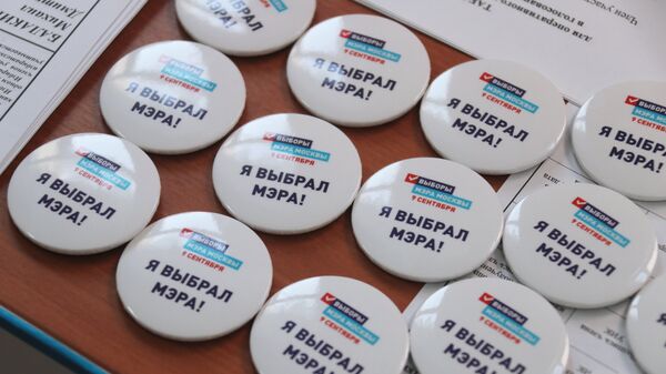 Памятные значки на столе в единый день голосования на избирательном участке в Москве