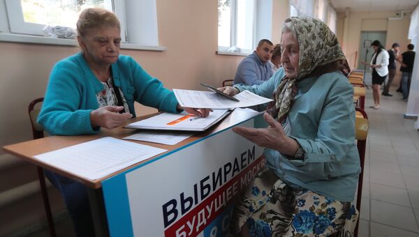 Избирательница и наблюдатель в единый день голосования на избирательном участке в Москве