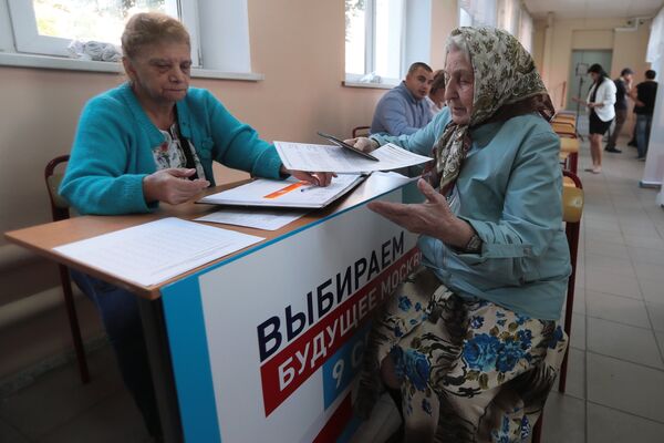 Избирательница и наблюдатель в единый день голосования на избирательном участке в Москве