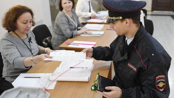 Сотрудник полиции голосует в единый день голосования. Архивное фото