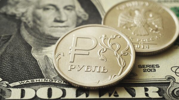 Монеты номиналом один рубль на банкноте один доллар США. Архивное фото