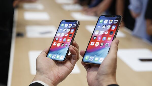 Человек держит новый Apple iPhone XS и XS Max. 12 сентября 2018 года