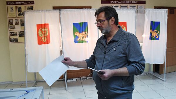 Мужчина голосует во втором туре выборов губернатора Приморского края на избирательном участке во Владивостоке