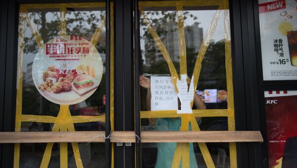 Работник закрывает ресторан перед прибытием супертайфуна Мангхут в Янцзяне в китайской провинции Гуандун, Китай. 16 сентября 2018 года