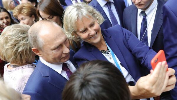 Президент РФ Владимир Путин фотографируется с участницей второго Евразийского женского форума в Таврическом дворце в Санкт-Петербурге. 20 сентября 2018
