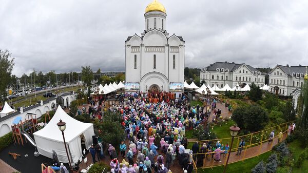 Верующие во время молебна у храма Спаса Нерукотворного Образа в селе Усово в Московской области