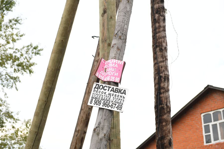 На столбах висят объявления о продаже щебня и дров