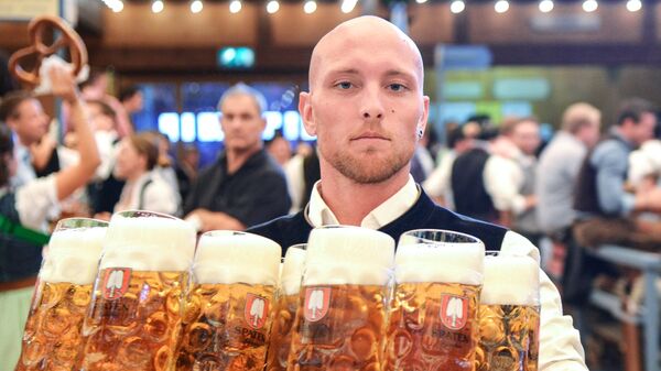 Официант разносит бокалы с пивом на открытии традиционного пивного фестиваля Октоберфест в Мюнхене