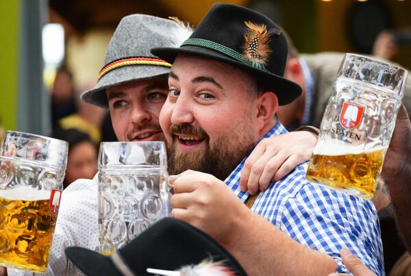 Посетители с бокалами пива на открытии традиционного пивного фестиваля Октоберфест в Мюнхене