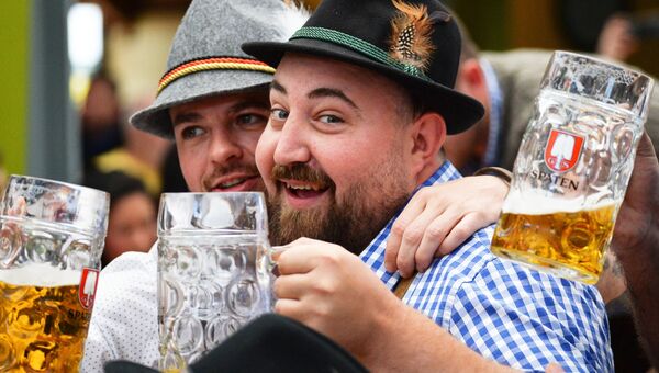 Посетители с бокалами пива на открытии традиционного пивного фестиваля Октоберфест в Мюнхене
