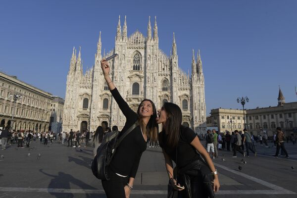 Туристы делают селфи перед собором Дуомо в Милане