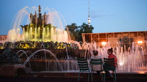 Девушки отдыхают у фонтана Каменный цветок на ВДНХ в Москве