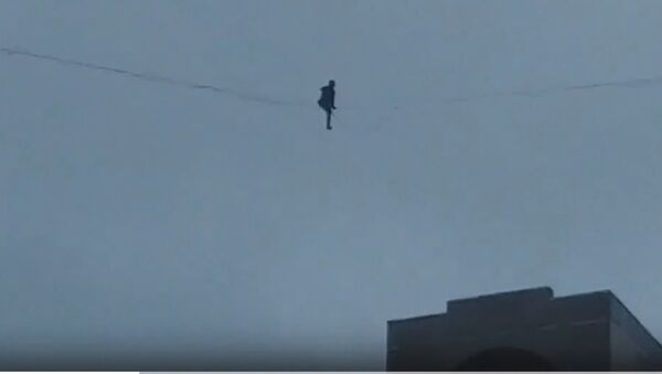В Петербурге неизвестный прошел по тросу между многоэтажками в шторм. Скриншот видео