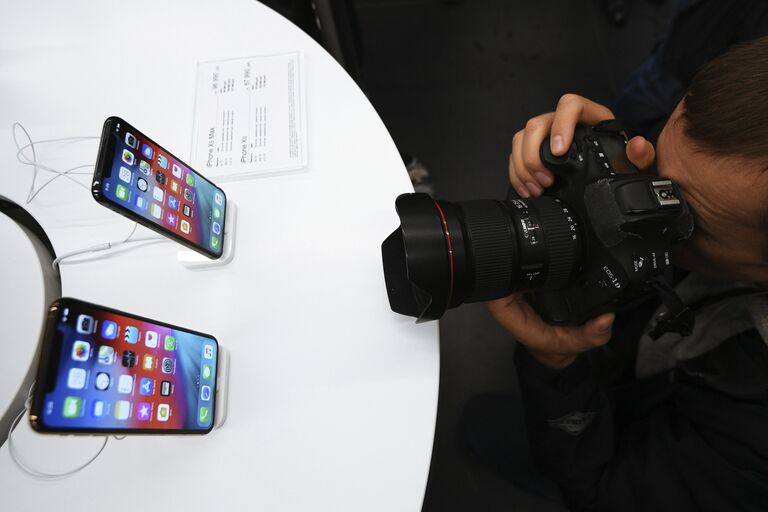 Фоторепортер фотографирует телефоны iPhone XS и iPhone XS Max в магазине re:Store на Тверской улице в Москве